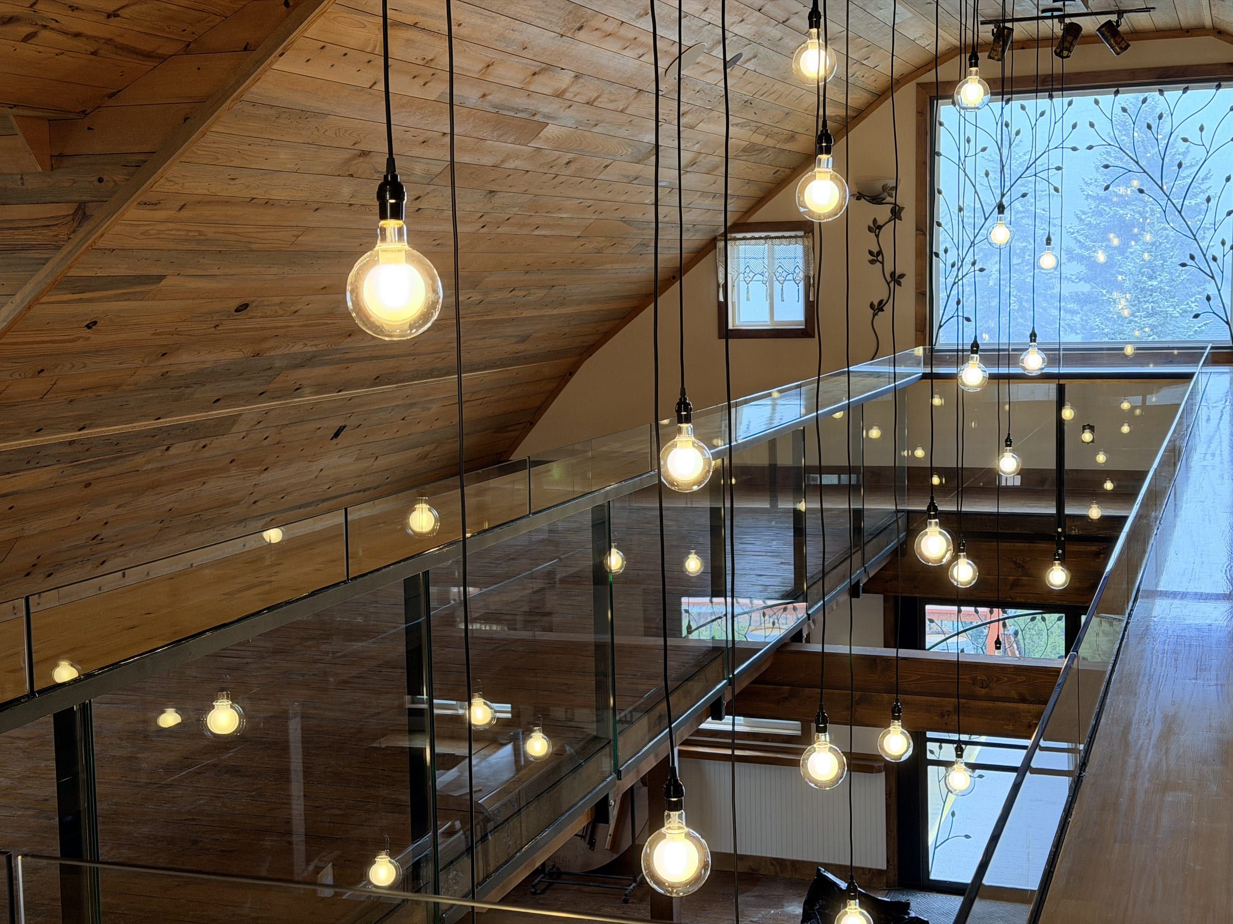 Timber loft with glass railings and hanging bulb lights