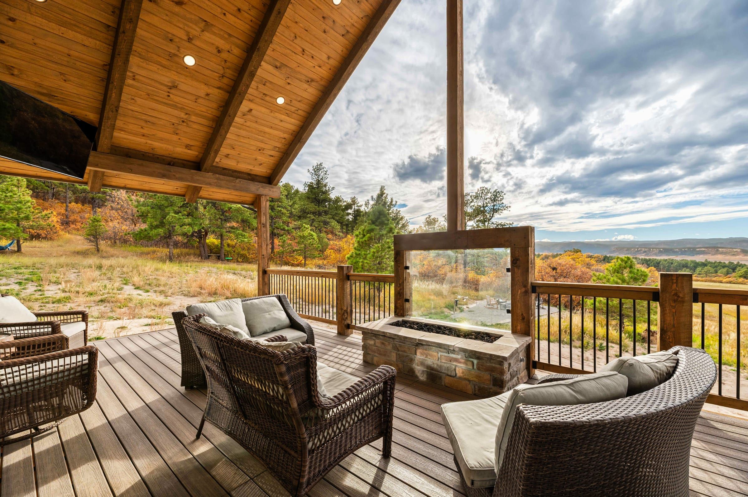 Covered deck with a stone fire table and views over autumn hills