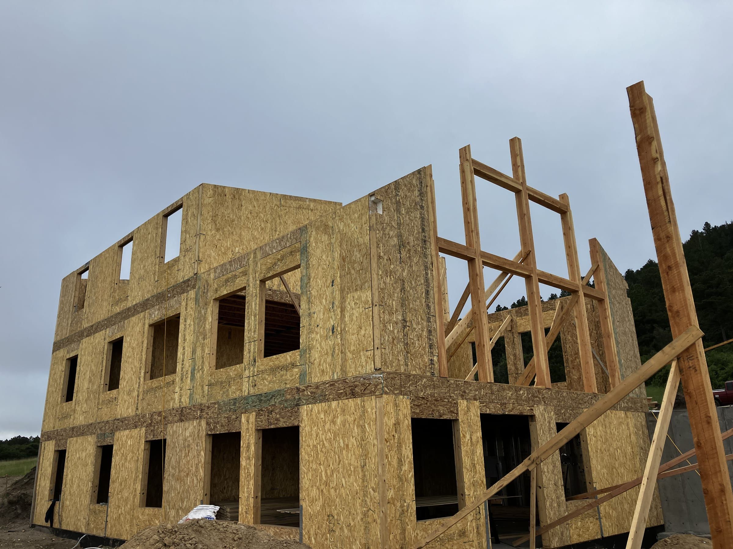 Two-story wood framing and sheathing going up on a foundation