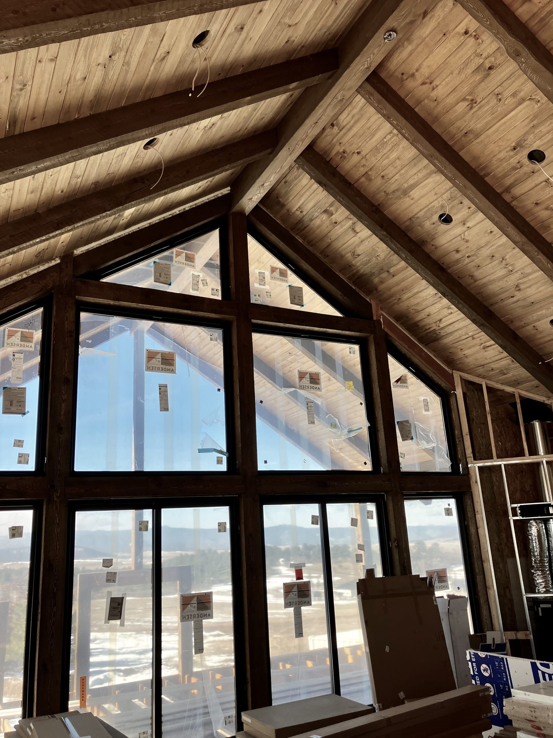 Tall gable windows framed in timber under a wood ceiling